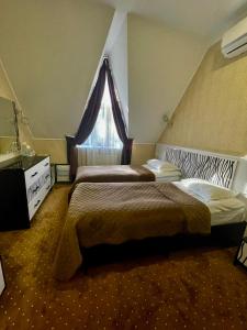 a hotel room with two beds and a window at VitaPark Stariy Dub in Truskavets