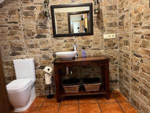 a stone bathroom with a sink and a toilet at EL RIBAZO-Cuenca ciudad in Cuenca