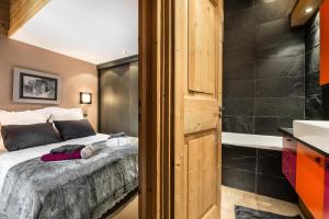 - une chambre avec un lit et une baignoire dans l'établissement Residence Calendal - 2 Pièces pour 4 Personnes 884, à Val dʼIsère