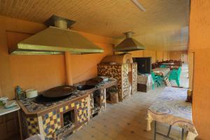 a kitchen with a stove with pots and pans on it at Сабзавот Давр Дача in Yalanghoch