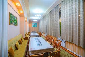 a dining room with a long table and chairs at Сабзавот Давр Дача in Yalanghoch
