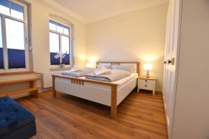 1 dormitorio con 1 cama blanca y 2 ventanas en FeWo 1 "Birkenast" 1OG inkl Strandkorb, en Dahme