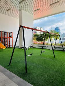 - une balançoire dans une pièce avec de l'herbe verte dans l'établissement KLCC suites by Chambers, à Kuala Lumpur