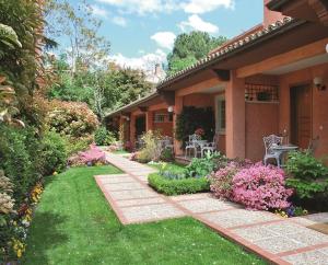 a house with a garden with flowers and plants at La Quinta de los Cedros in Madrid