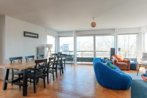 - un salon avec un canapé bleu, une table et des chaises dans l'établissement Bright and charming apartment - On Boulogne, à Boulogne-Billancourt