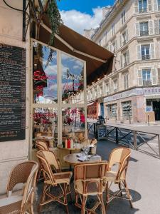 un restaurant avec des chaises et des tables en face d'un bâtiment dans l'établissement Bright and charming apartment - On Boulogne, à Boulogne-Billancourt