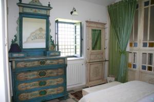 a bedroom with a dresser with a mirror on it at Dar Chennoufi in Sicca Veneria