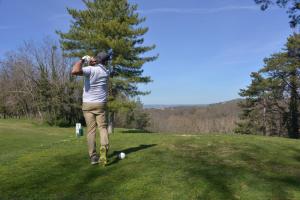 un hombre tomando una foto de una pelota de golf en Best Western Golf d'Albon, en Albon