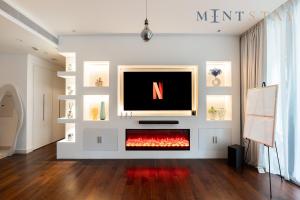 a living room with a fireplace with a tv at City Walk Building 2B - Al Wasl, Jumeirah - Mint Stay in Dubai