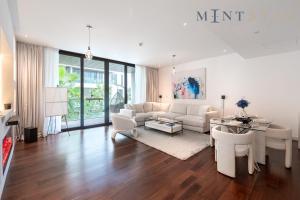 un soggiorno con mobili bianchi e tavolo di City Walk Building 2B - Al Wasl, Jumeirah - Mint Stay a Dubai