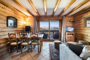 a dining room with a table and chairs and a window at Résidence Balcons De Pralong - 4 Pièces pour 6 Personnes 064 in Courchevel