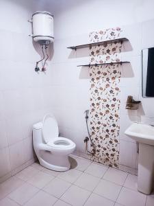 y baño con aseo y lavamanos. en Hotel Satguru Indrapuram, Shaktikhand, en Ghaziabad