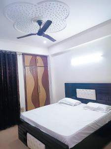 1 dormitorio con 1 cama y ventilador de techo en Hotel Satguru Indrapuram, Shaktikhand, en Ghaziabad