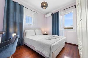 ein weißes Schlafzimmer mit einem Bett und einem Fenster in der Unterkunft A&M apartment Lefkada in Lefkada Town