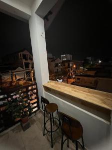 - deux chaises assises au bar sur un balcon la nuit dans l'établissement canary homestay-We love having you here! Nguyên căn, à Hue