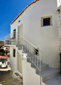 a white house with stairs and a window at Lythi Kythnos in Kithnos