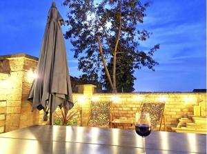 kieliszek wina siedzący na stole obok parasola w obiekcie Luxury Lincoln Home with hot tub sleeps 8 w mieście Lincoln