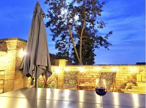 a glass of wine sitting on a table next to an umbrella at Luxury Lincoln Home with hot tub sleeps 8 in Lincoln