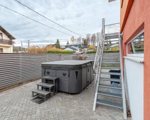 a patio with a grill and a ladder next to a building at President Apartments in Vilnius