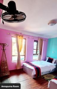 a bedroom with pink and blue walls and a bed at Annapurna Guest House and Rooftop Restaurant in Bhaktapur