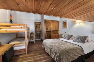 a bedroom with two bunk beds and wooden ceilings at Résidence Roc Mugnier - Chalets pour 8 Personnes 504 in Courchevel