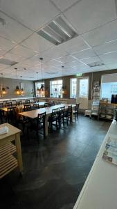 restauracja ze stołami i krzesłami w pokoju w obiekcie Hafnarstræti Hostel w Akureyri