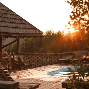 a deck with a bench and a swimming pool at Korunka in Tatariv