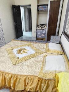 uma cama com uma colcha amarela num quarto em Ганга центр люкс em Tashkent