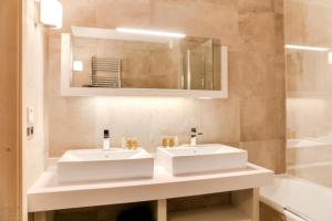 ein Badezimmer mit zwei Waschbecken, einem Spiegel und einer Badewanne in der Unterkunft Résidence Carre Blanc - 5 Pièces pour 8 Personnes 264 in Courchevel