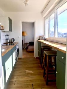 a kitchen with green cabinets and a wooden floor at Perfect for couples+children / baby friendly /50m² in Paris