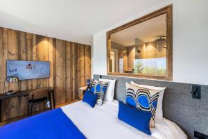 een slaapkamer met een groot bed met blauwe kussens bij Résidence Horizon Blanc - 4 Pièces pour 6 Personnes 314 in Courchevel