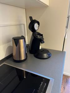 a table with a coffee pot and a clock on it at Tolles Apartment mitten im Herzen von Herdecke- Mola 2 in Herdecke