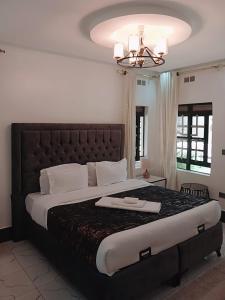 a bedroom with a large bed with a large headboard at Cacecy Luxury Homes 2 -Bedroom in Bungoma