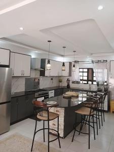 a kitchen with a large island with bar stools at Cacecy Luxury Homes 2 -Bedroom in Bungoma
