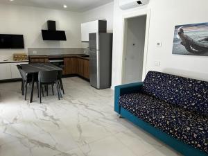 ein Wohnzimmer mit einem Sofa und einem Tisch sowie eine Küche in der Unterkunft Residence La Margherita in Lazise