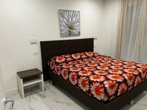 a bedroom with a bed with a flower comforter at Residence La Margherita in Lazise