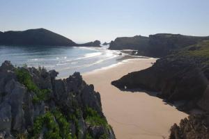una playa con rocas grandes y el océano en Apartamento 3Banes, en Llanes