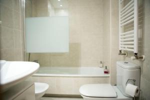 un baño con inodoro y bañera en Apartamento 3Banes, en Llanes 16 fotos más