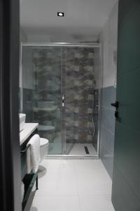 a bathroom with a shower and a toilet and a sink at Aybek Ratio Hotel in Canakkale