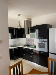 - une cuisine avec des armoires noires et une cuisinière dans l'établissement Appartamento ad Acilia, à Acilia