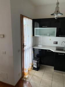 - une cuisine avec un comptoir blanc et un évier dans l'établissement Appartamento ad Acilia, à Acilia