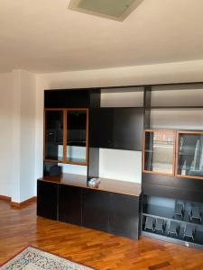 Il comprend une cuisine avec des armoires noires et du parquet. dans l'établissement Appartamento ad Acilia, à Acilia
