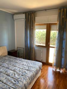 - une chambre avec un lit et 2 fenêtres avec des rideaux dans l'établissement Appartamento ad Acilia, à Acilia