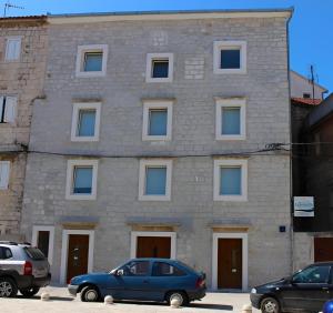 a building with cars parked in front of it at Apartments Leonarda in Trogir