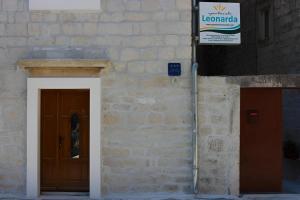 a building with a door and a sign on it at Apartments Leonarda in Trogir