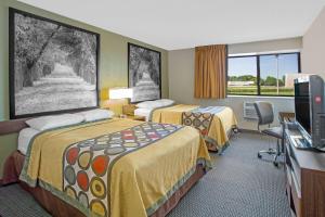 a hotel room with two beds and a television at Super 8 by Wyndham Windsor/Madison North in Windsor