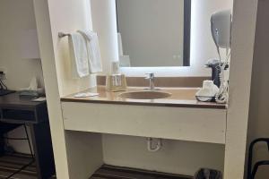 a bathroom with a sink and a mirror at Super 8 by Wyndham Nebraska City in Percival
