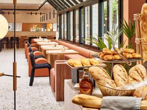 une rangée de tables avec des assiettes de pain et des pâtisseries dans l'établissement Mercure Paris 15 Porte de Versailles, à Paris