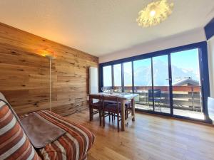 a dining room with a table and a large window at Sequoias - 102 - Appart moderne 4 pers in Les Deux Alpes +4 photos