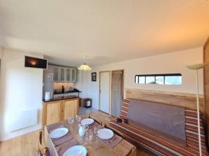 a living room with a table and a kitchen at Sequoias - 102 - Appart moderne 4 pers in Les Deux Alpes